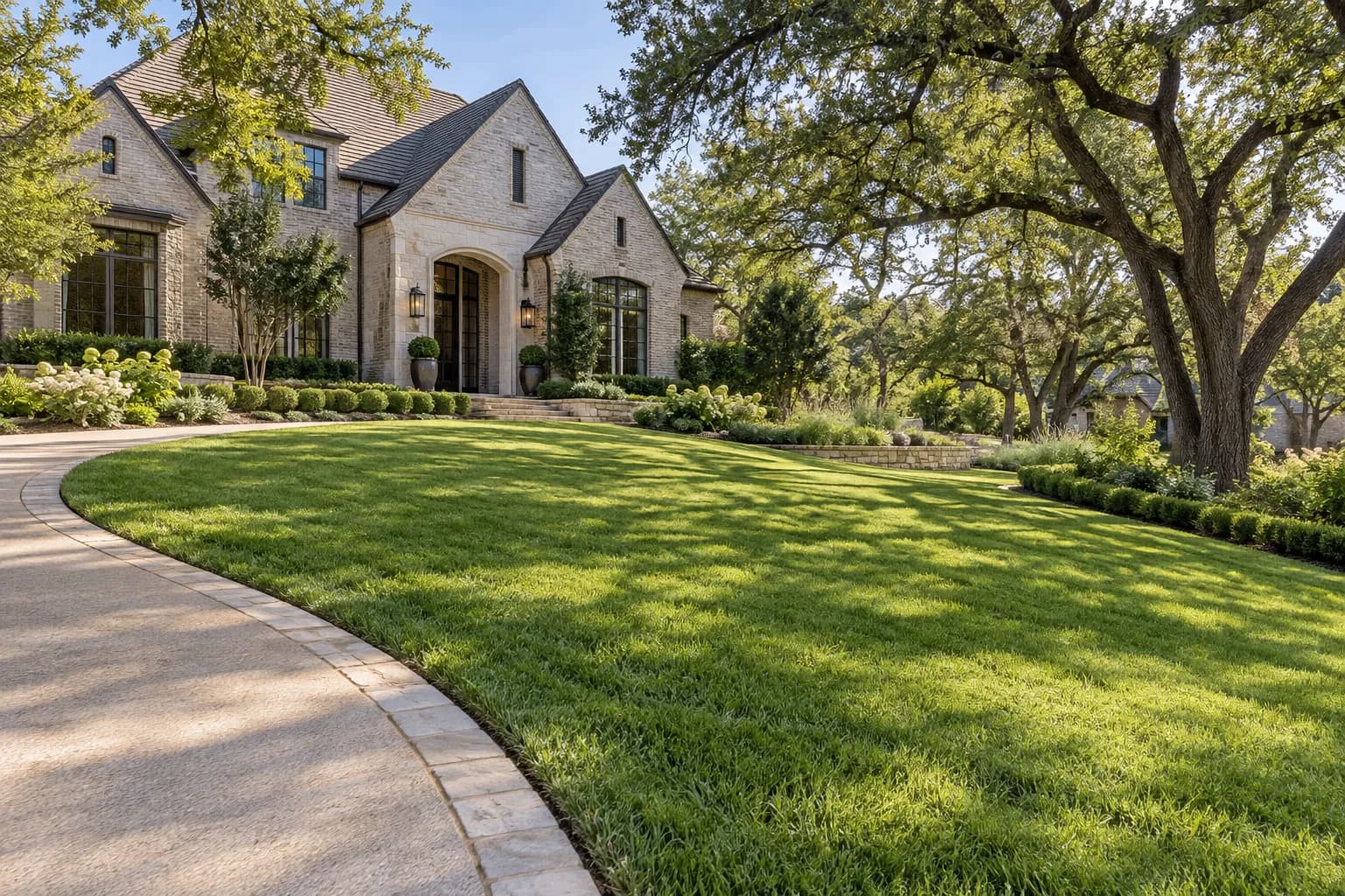 Gently sloping lawn, curved drive and low limestone planting border